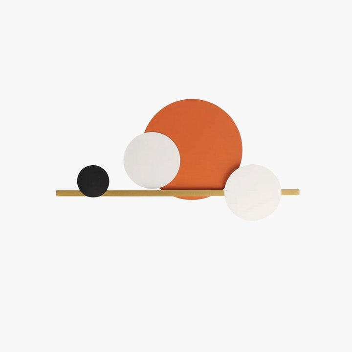 Modern circular wall art featuring black, white, and orange circles on a gold bar, perfect for accent wall lighting.