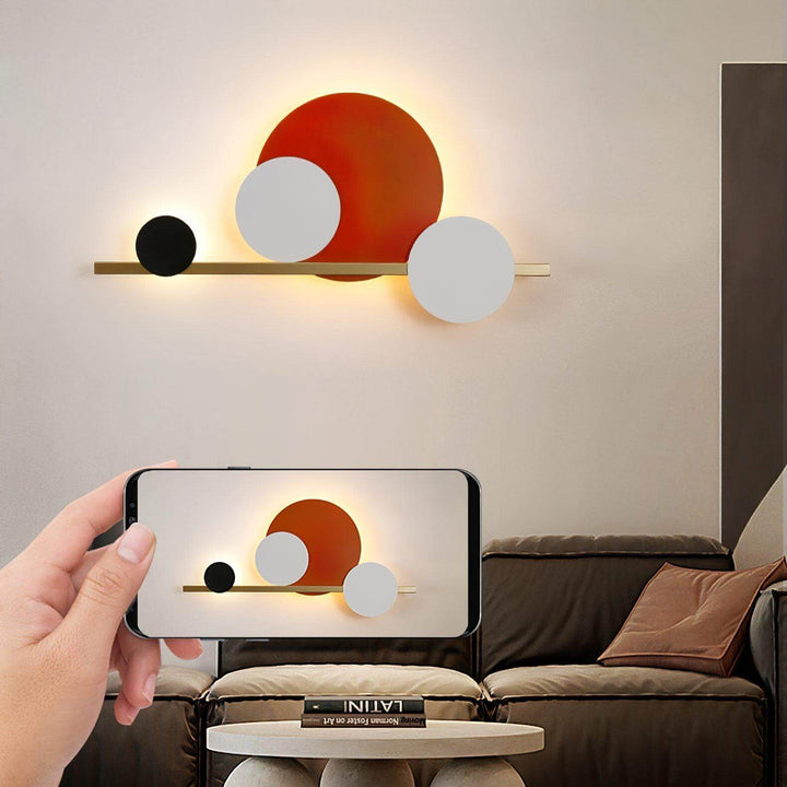Modern circle LED wall sconce illuminating a stylish living room with abstract design elements.