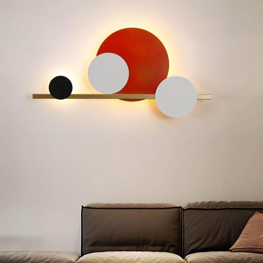 Modern wall sconce lighting featuring three circles in red, black, and white, perfect for accent wall lighting in a bedroom.