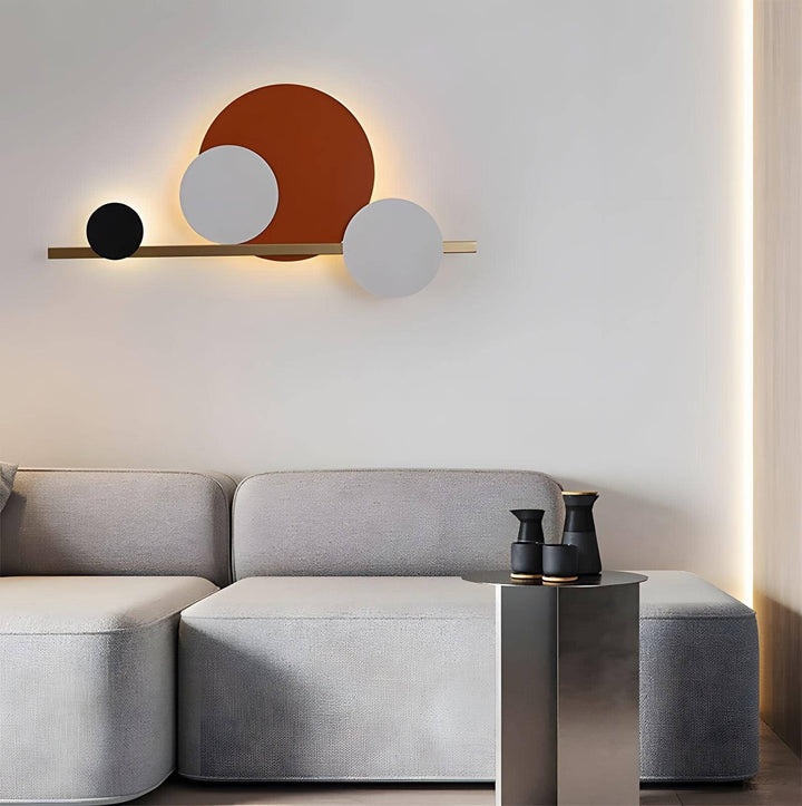 Modern circular LED wall sconce lighting above a stylish grey couch, perfect for accent wall lighting in bedrooms.