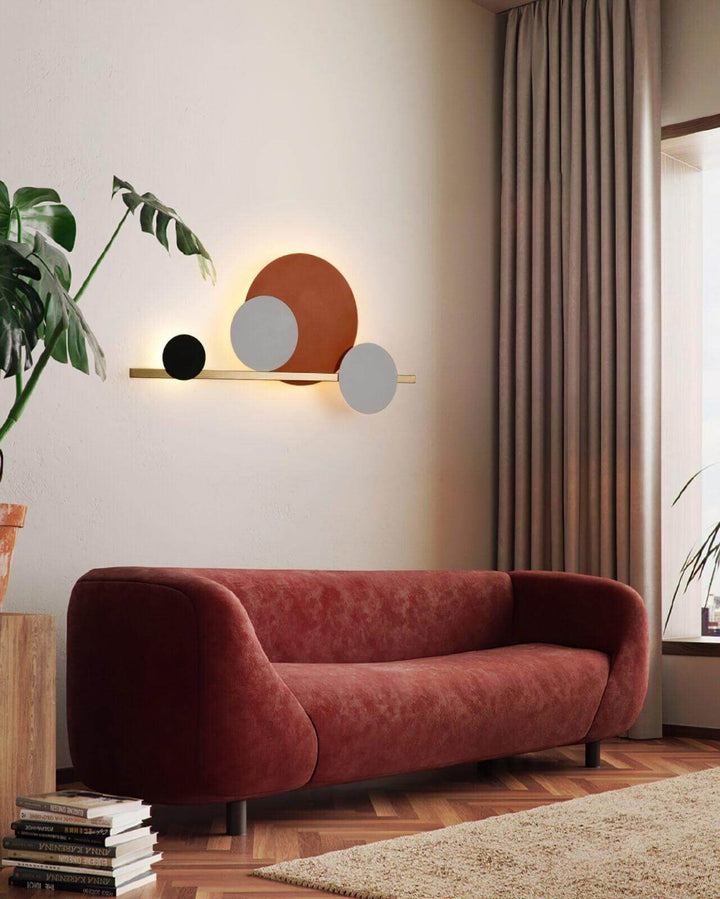 Modern 4 Circle LED wall sconce lighting above a red sofa, adding accent wall lighting to a stylish living room.
