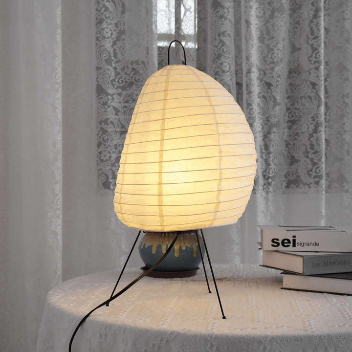 Akari 1N minimal table lamp with white shade on a table, creating a cozy Japandi style ambiance.