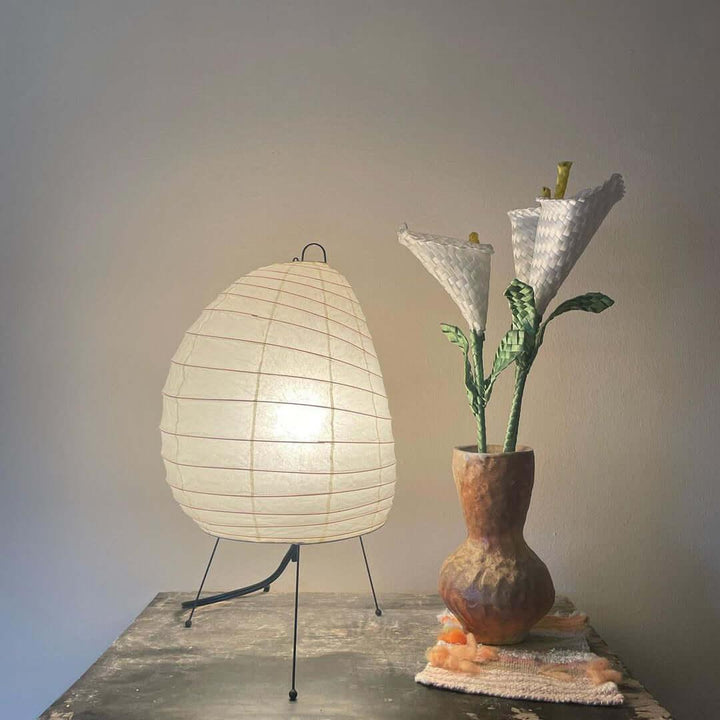 Akari 1N Japandi table lamp with minimalist design, white shade, beside a unique flower vase.