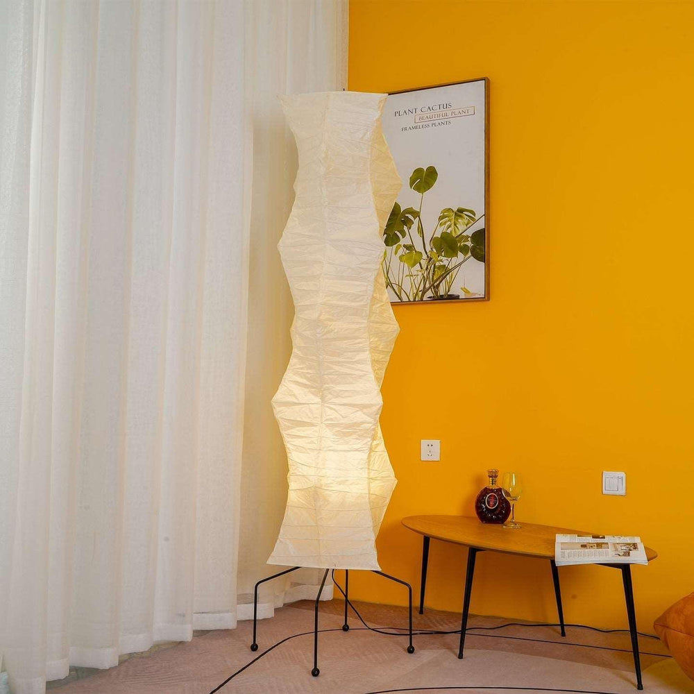 Akari UF4-33N white rice paper floor lamp in minimalist design for modern interiors, standing tall against an orange wall.