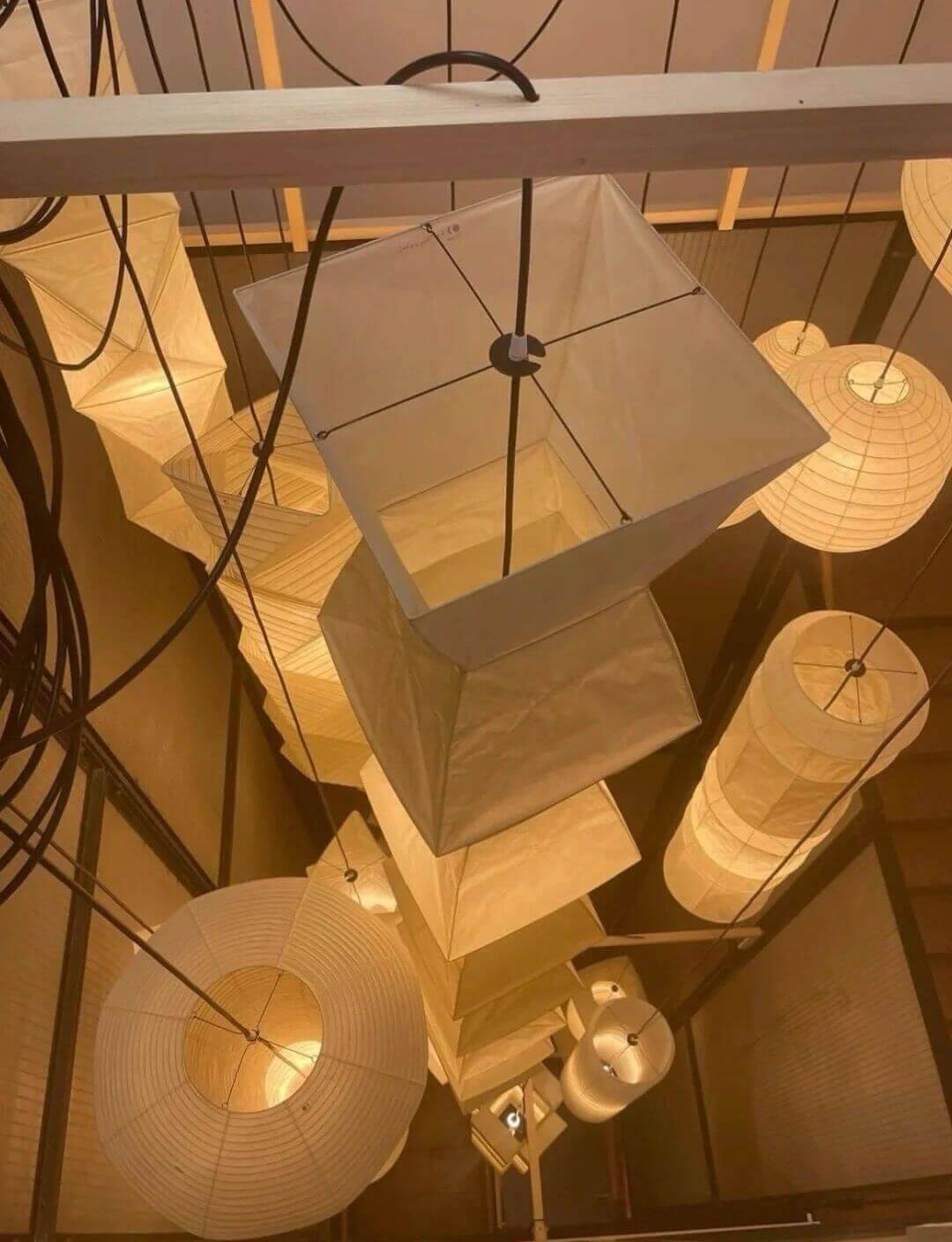 Overhead view of rice paper lanterns including a minimalist white floor lamp for a modern aesthetic.
