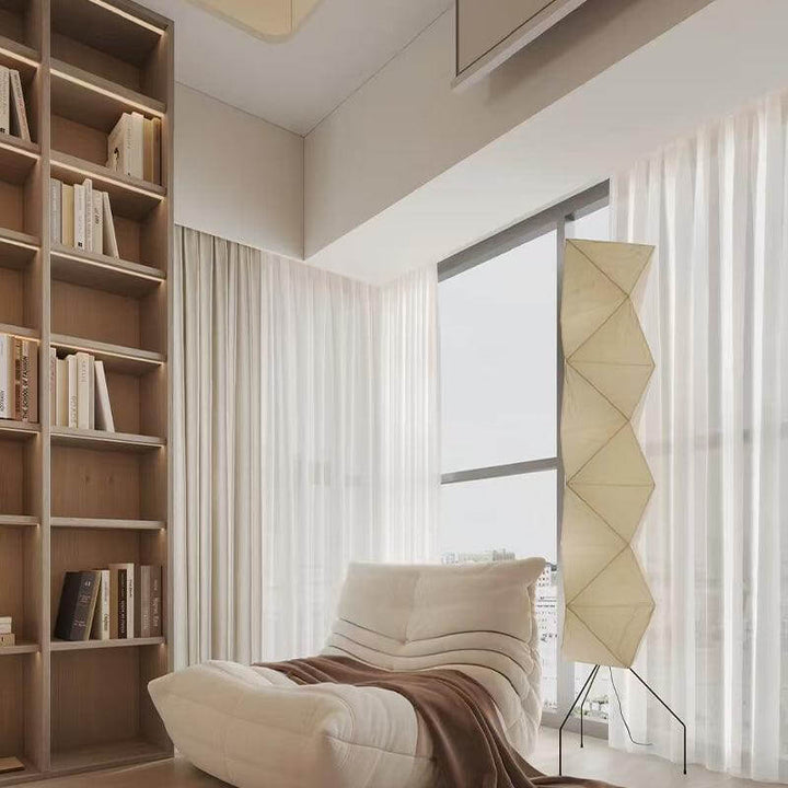 Minimalist Japanese white floor lamp in a modern living room with large windows and cozy furniture.
