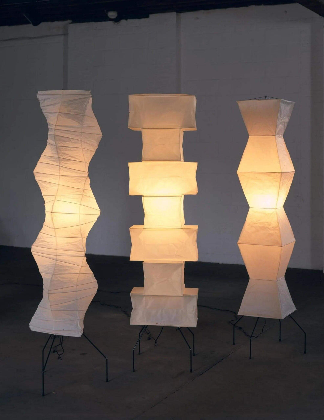 Three elegant Akari UF4-L8 floor lamps in white rice paper, showcasing minimalist and Japanese lantern design.