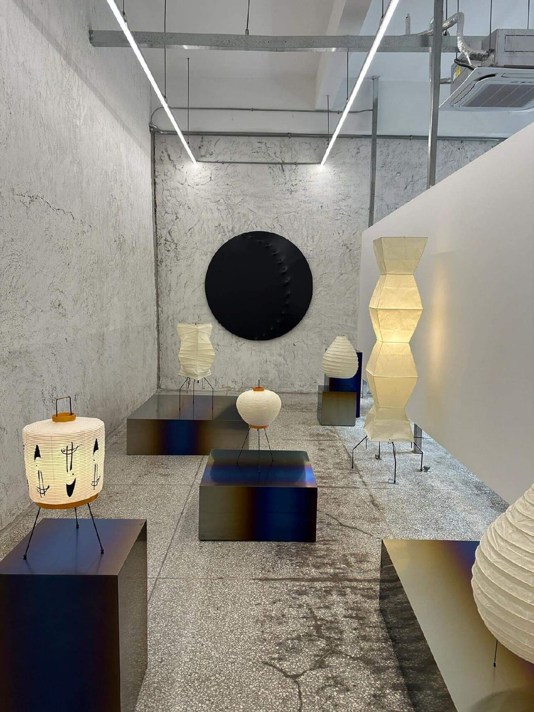 Stylish display of white rice paper floor lamps in a minimalist interior, highlighting Japanese design with tripod bases.