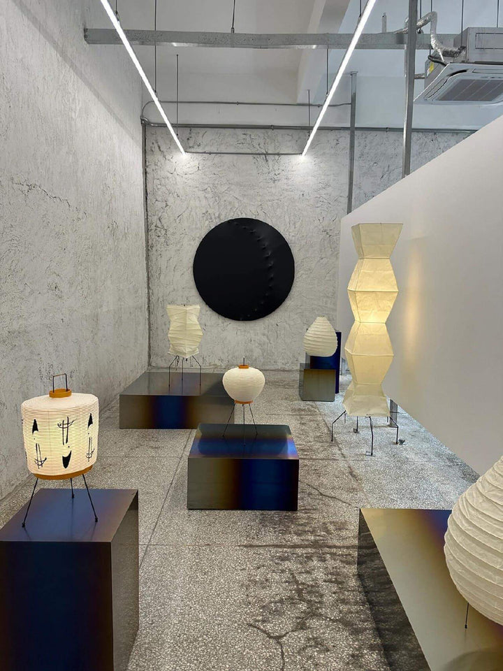 Stylish display of white rice paper floor lamps in a minimalist interior, highlighting Japanese design with tripod bases.