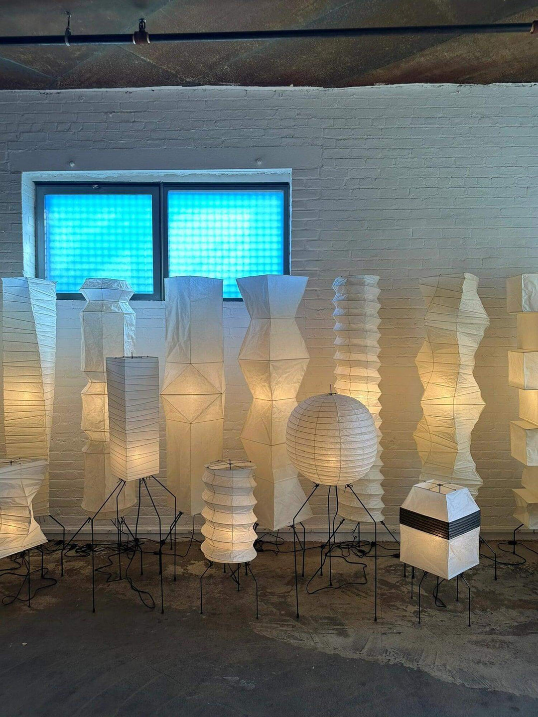Minimalist white floor lamps made of rice paper, showcasing various designs and shapes in a modern interior.