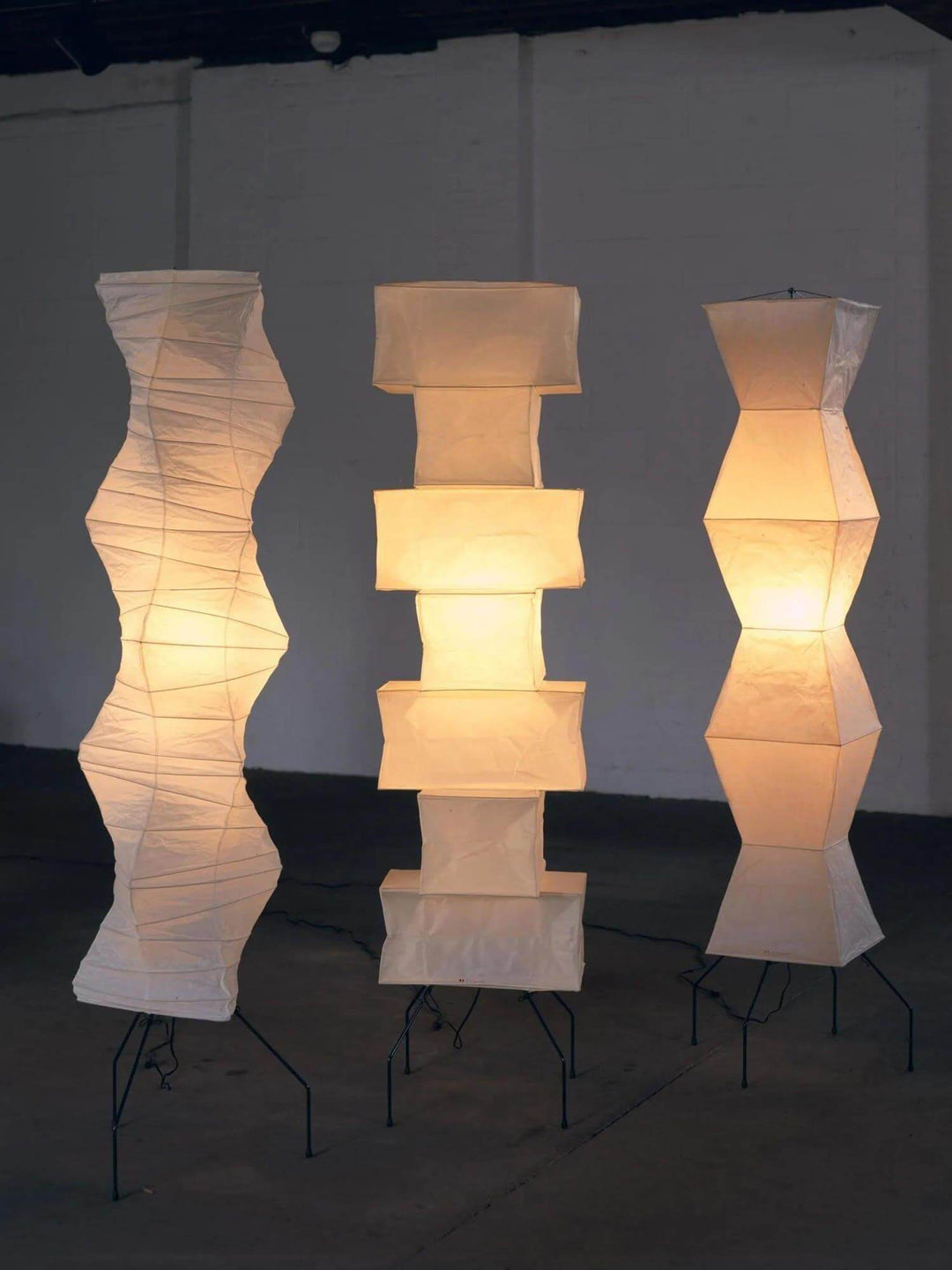 Three elegant rice paper floor lamps showcasing minimalist Japanese design, perfect for adding warmth to any space.
