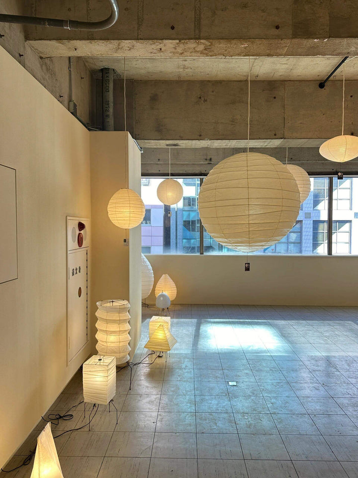 Modern Japanese-inspired lighting in minimalist space with different shapes of washi paper lamps and natural light.