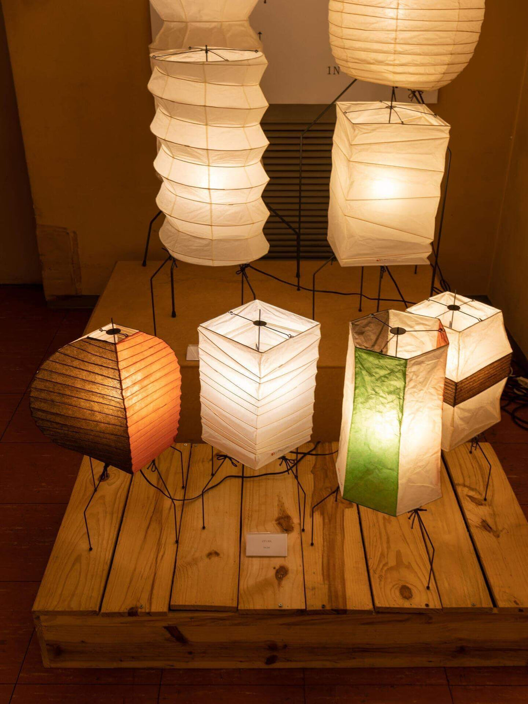 Various modern tripod table lamps in a warm setting, showcasing unique washi paper designs for a stylish living room.