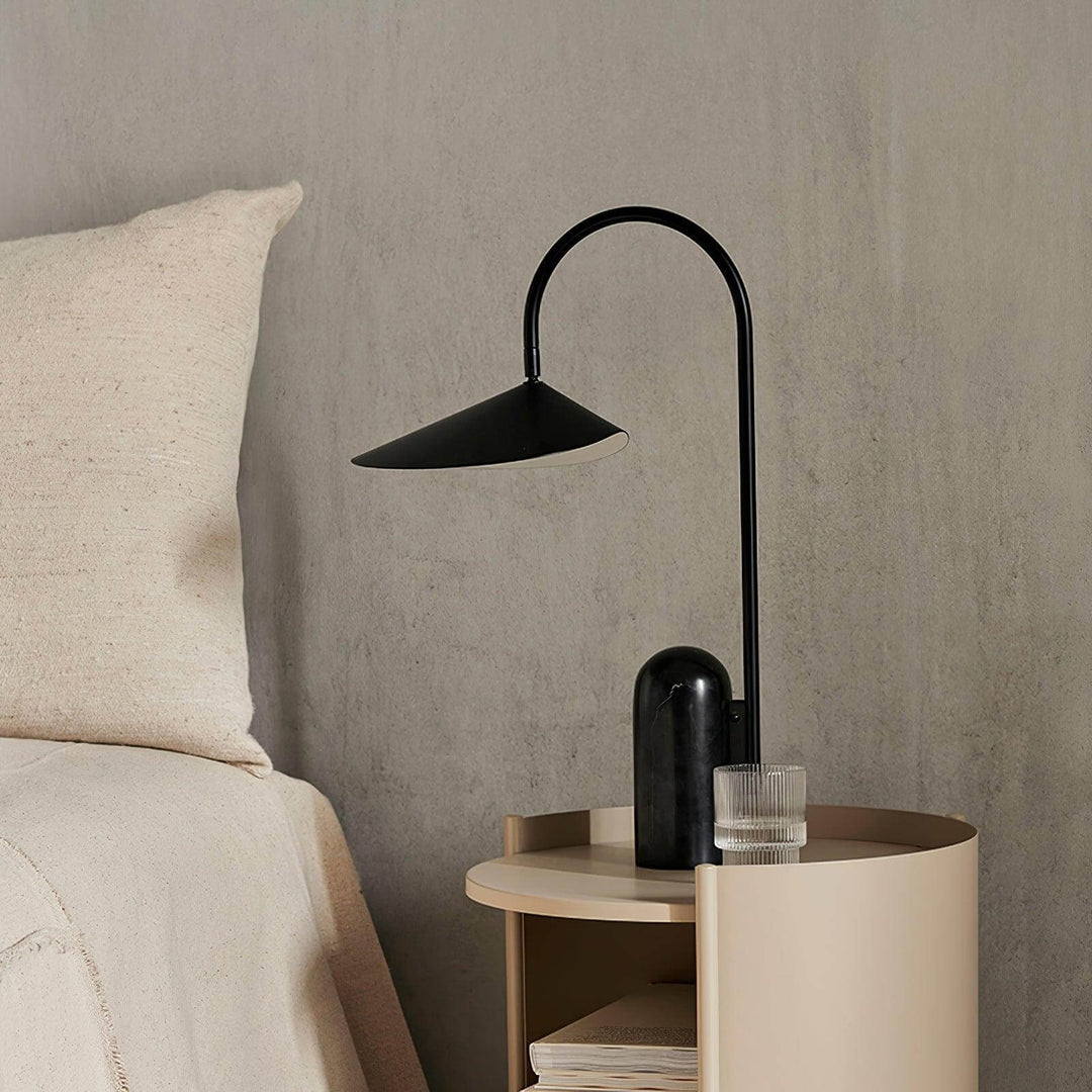 Black modern Arum table lamp on a bedside table, perfect for office and living room decor.