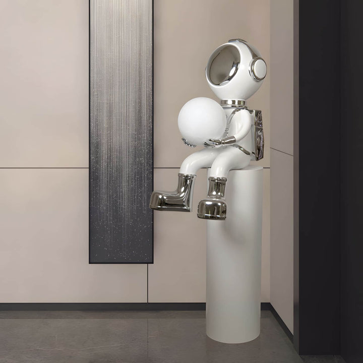 Sculptural astronaut figurine holding a globe, perfect for modern decor and art-inspired spaces.