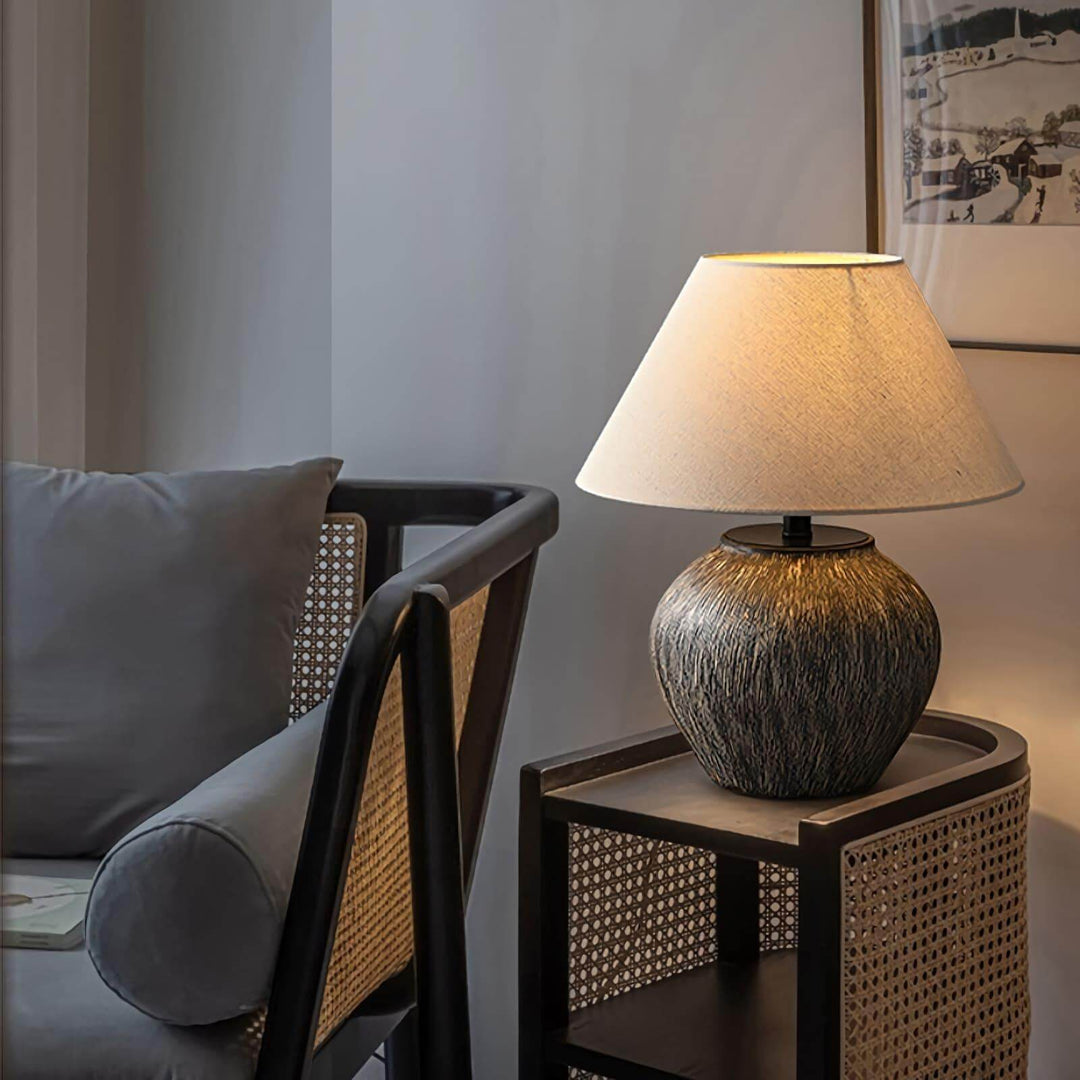 Bayi ceramic table lamp on a wooden side table next to a modern sofa, enhancing vintage decor style.