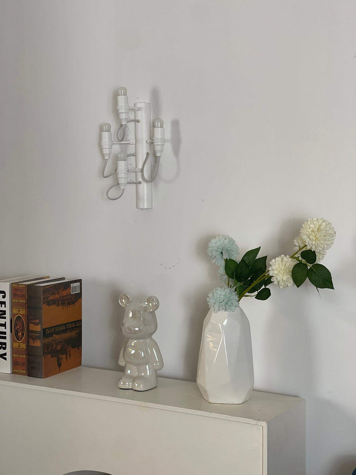 Classic 2097 mid century wall sconce above modern decor, including a vase and decorative books.