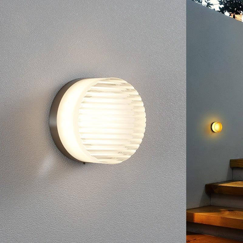 Crisp vintage round wall sconce in a stylish design, perfect for hallways and small spaces, with a nickel backplate.