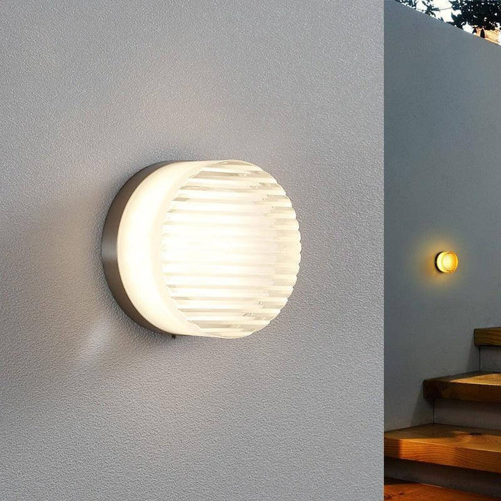 Crisp vintage round wall sconce in a stylish design, perfect for hallways and small spaces, with a nickel backplate.