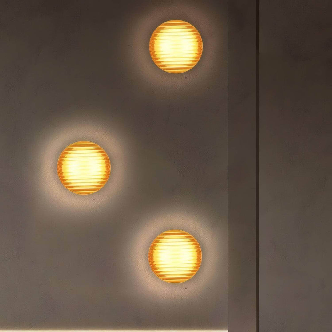 Three vintage round wall sconces on a textured wall, perfect lighting for hallways and small spaces.