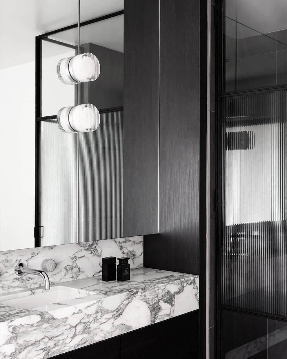 Modern bathroom design featuring marble countertop and stylish pendant lights for a sleek ambiance.