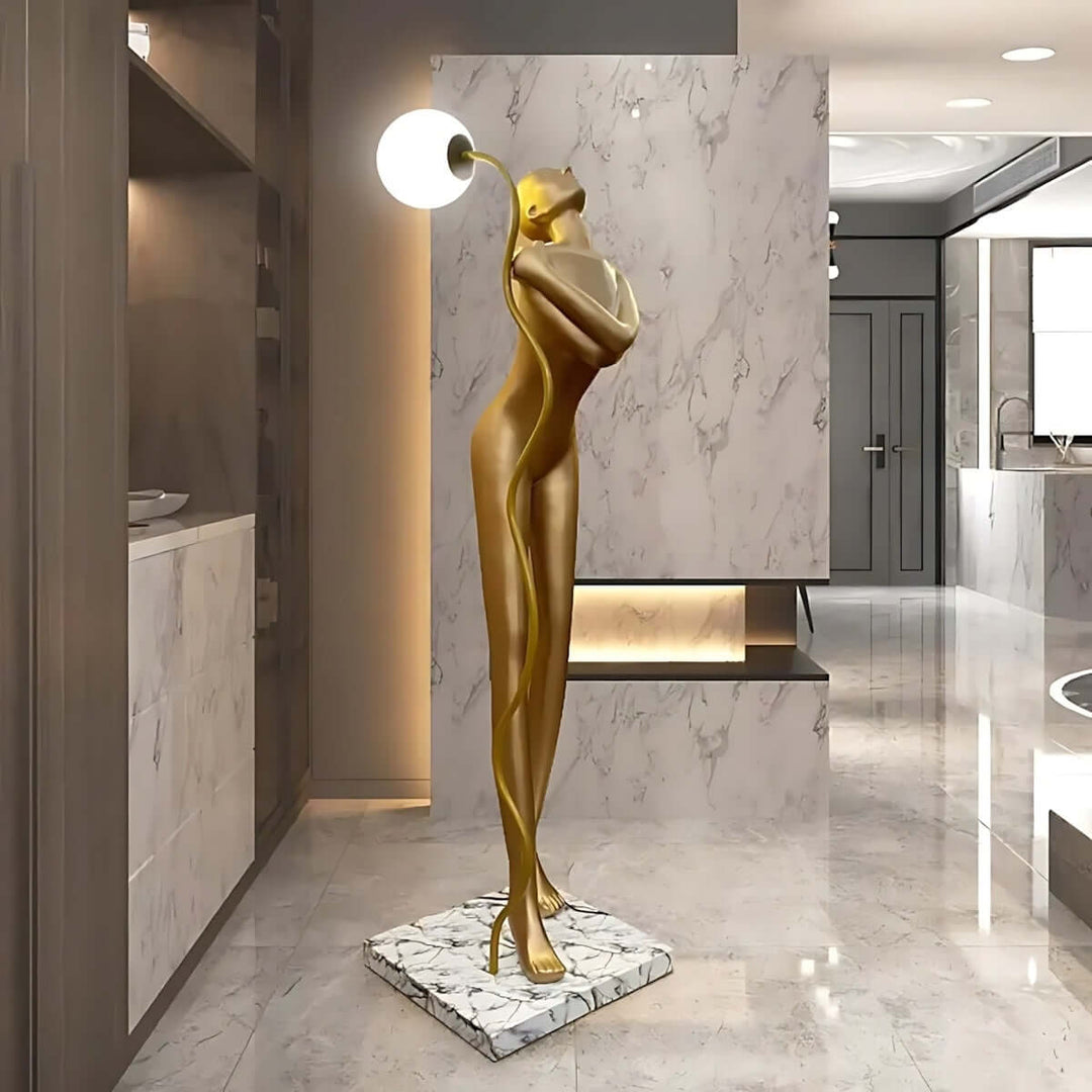 Sculptural art deco floor lamp with golden figure design, perfect for stylish living room lighting.