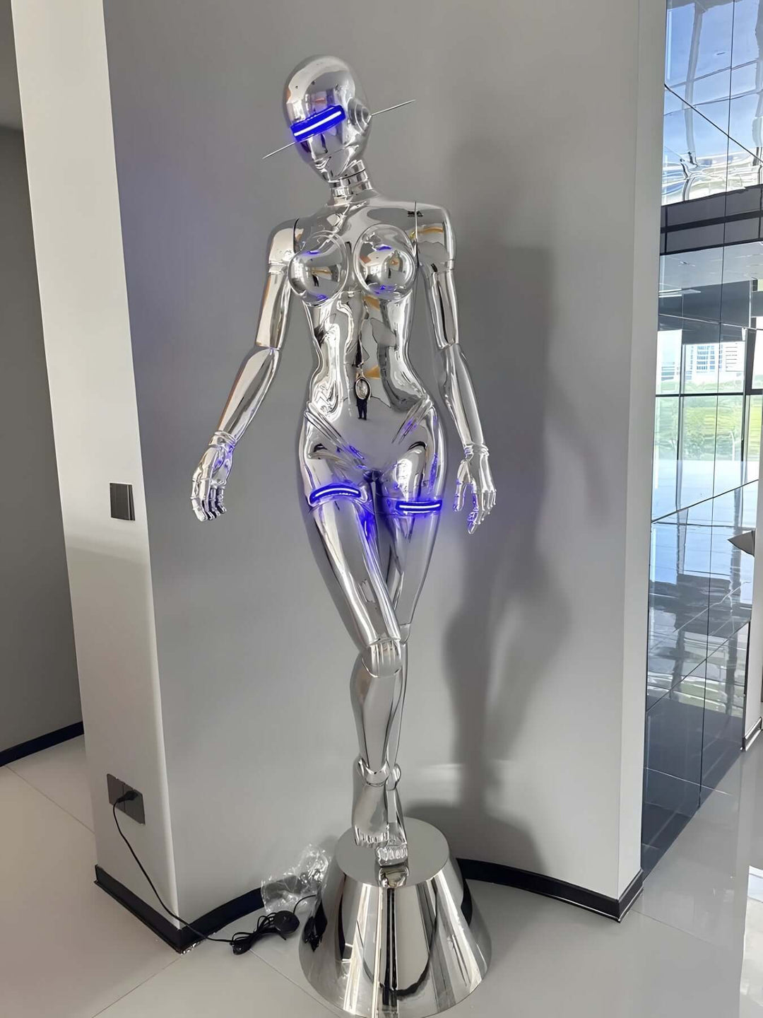 Sculptural silver mannequin lamp with neon accents, perfect for modern and art deco decor in upscale living spaces.