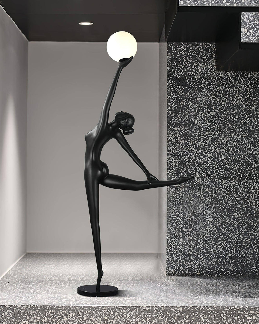 Sculptural Elvani resin floor lamp, a stunning art deco design for modern living rooms, featuring a black figure and round light.