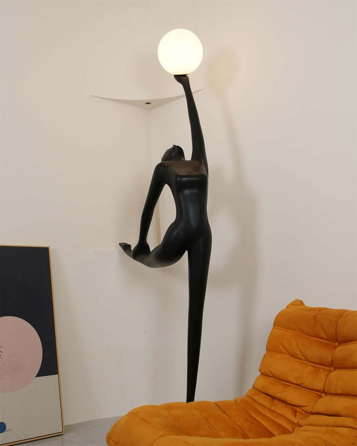 Sculptural floor lamp resembling a dancer, with a round light, enhancing modern living room decor.