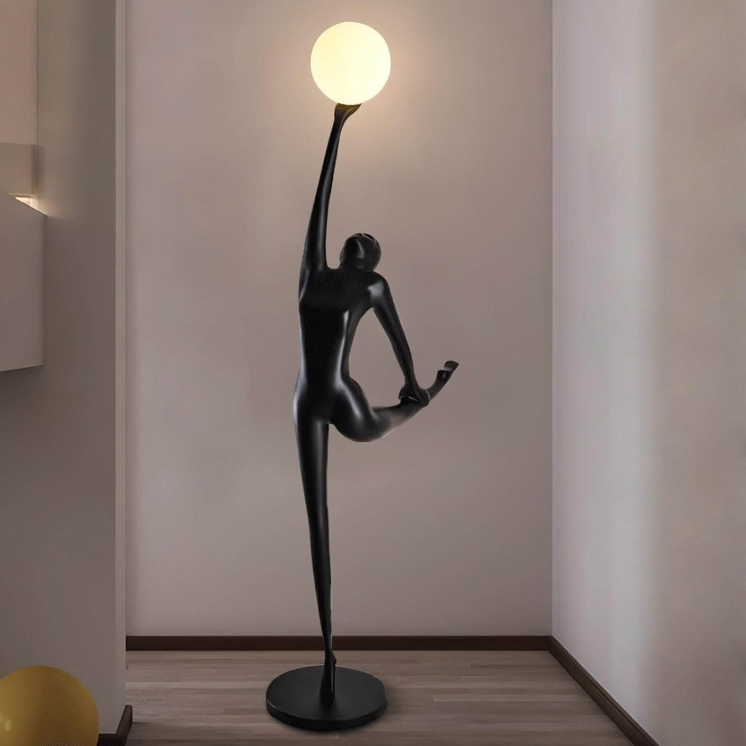 Sculptural floor lamp featuring an elegant human figure holding a glowing orb, perfect for modern living rooms.