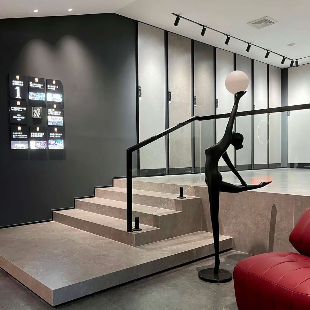 Sculptural floor lamp resembling a figure, providing elegant lighting in a modern stairwell setting.