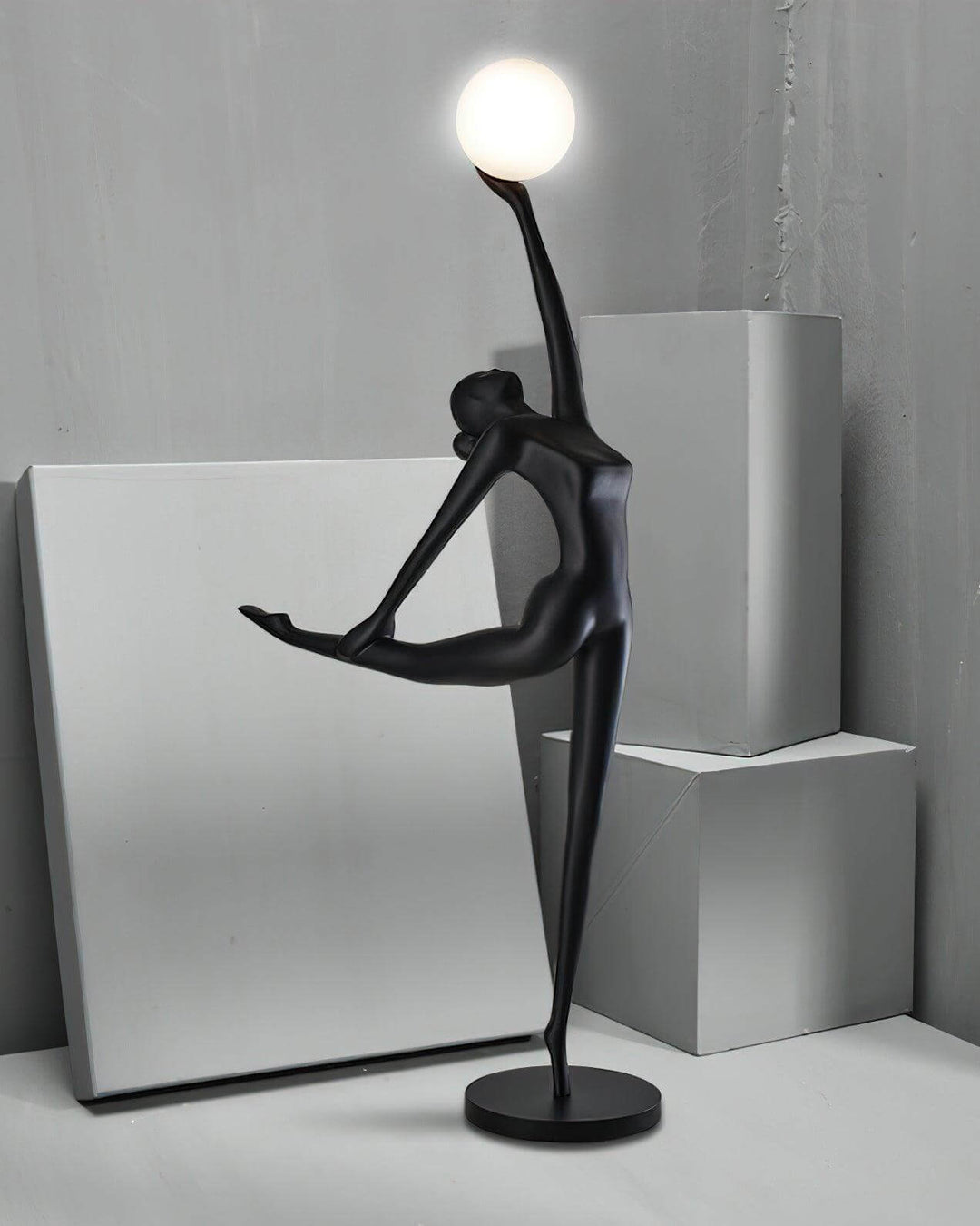 Sculptural Elvani resin floor lamp with a graceful figure holding a glowing orb, perfect for modern living room decor.