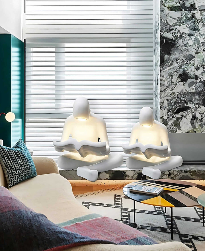 Sculptural floor lamp featuring two reading figures, perfect for art deco style living room lighting.