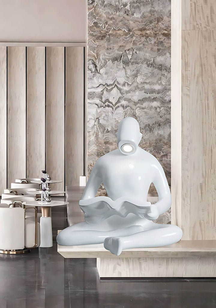 Art deco sculptural floor lamp featuring a seated figure reading, ideal floor lights for living room decoration.