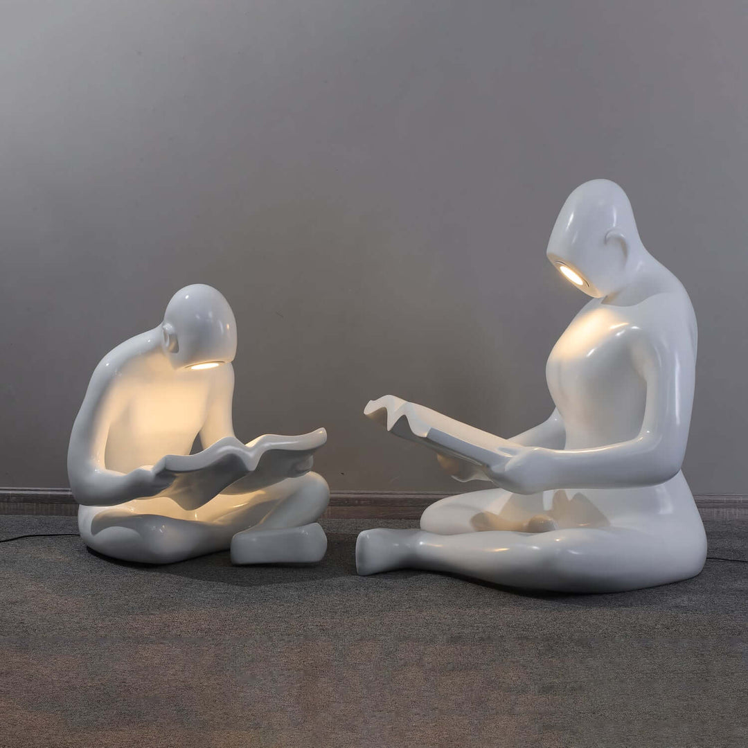 Sculptural floor lamp in art deco style featuring two figures reading, ideal floor lights for living room.