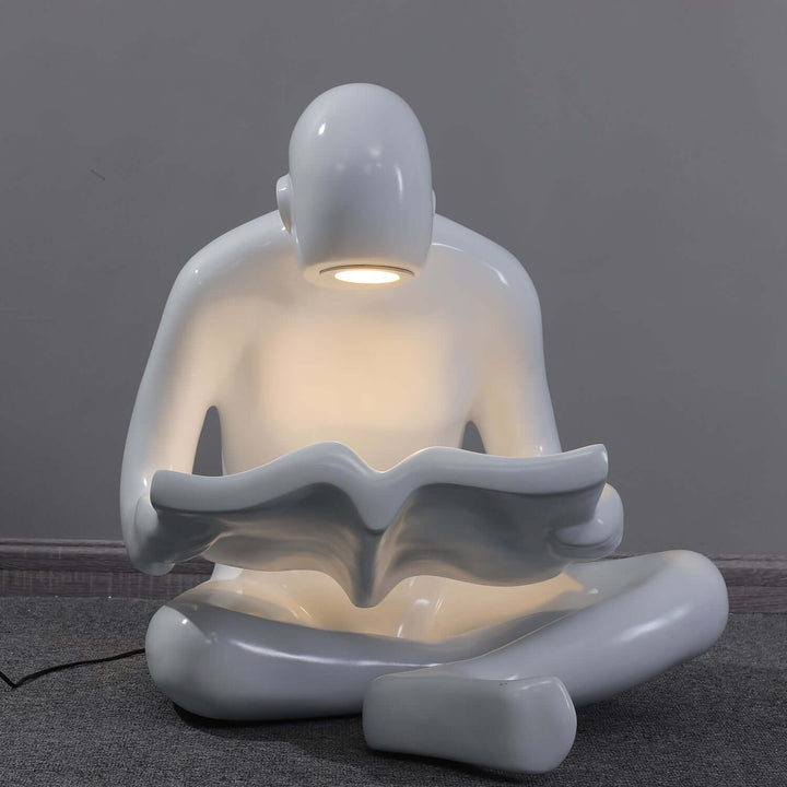 Elyvia sculptural floor lamp featuring a white reading figure, perfect for art deco decor in living rooms.