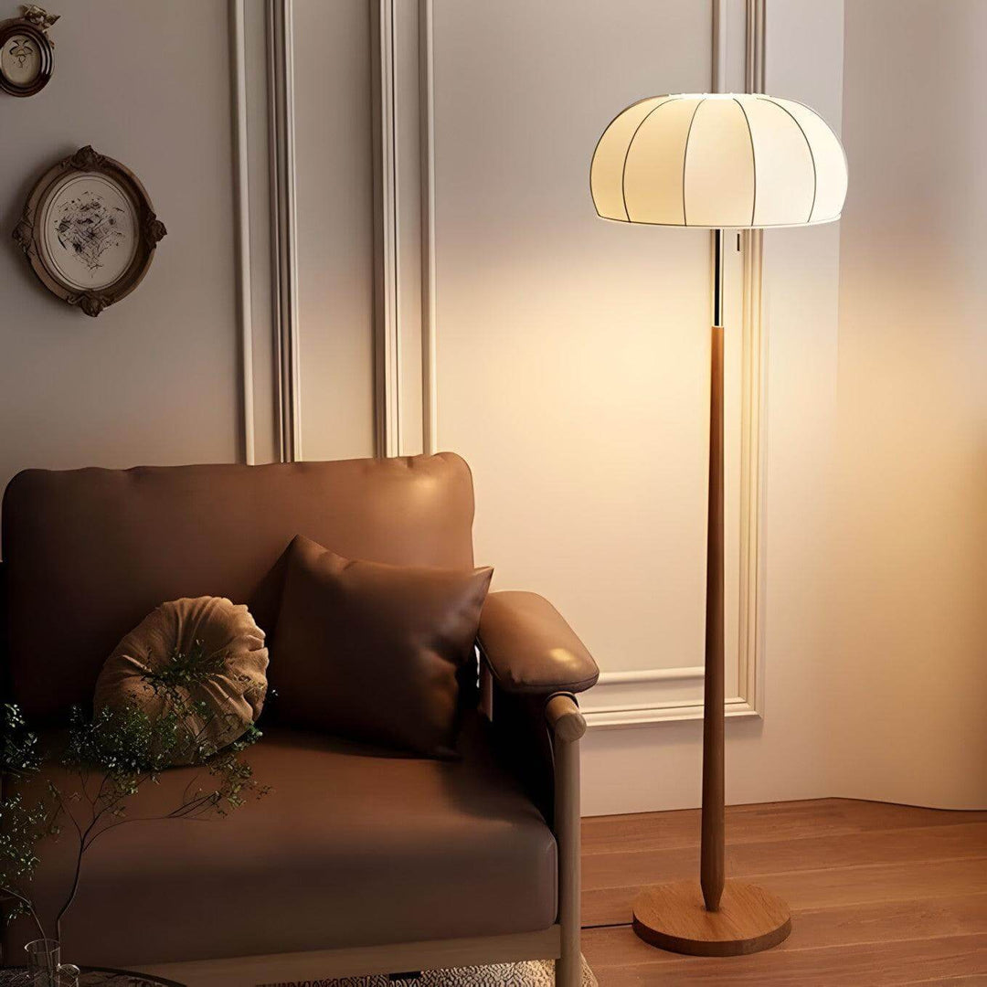 Gorra floor lamp in mid-century style with wood base, illuminating a cozy living area, perfect for farmhouse decor.