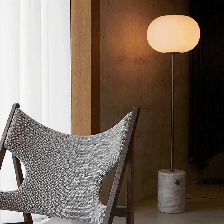 Modern floor lamp in a chic living room, complementing a stylish chair, perfect for reading and ambiance.