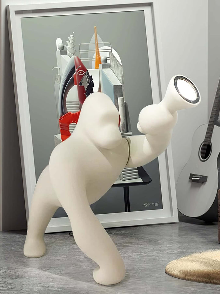 Kong sculpture floor lamp in a modern living room setting with abstract art and a guitar.