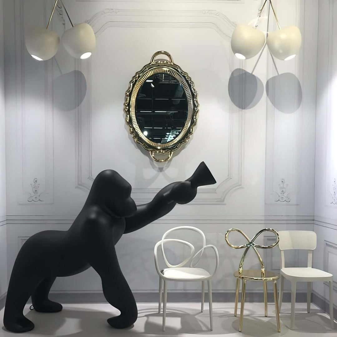 Sculptural floor lamp inspired by a gorilla, paired with elegant chairs and a vintage mirror in a stylish interior.