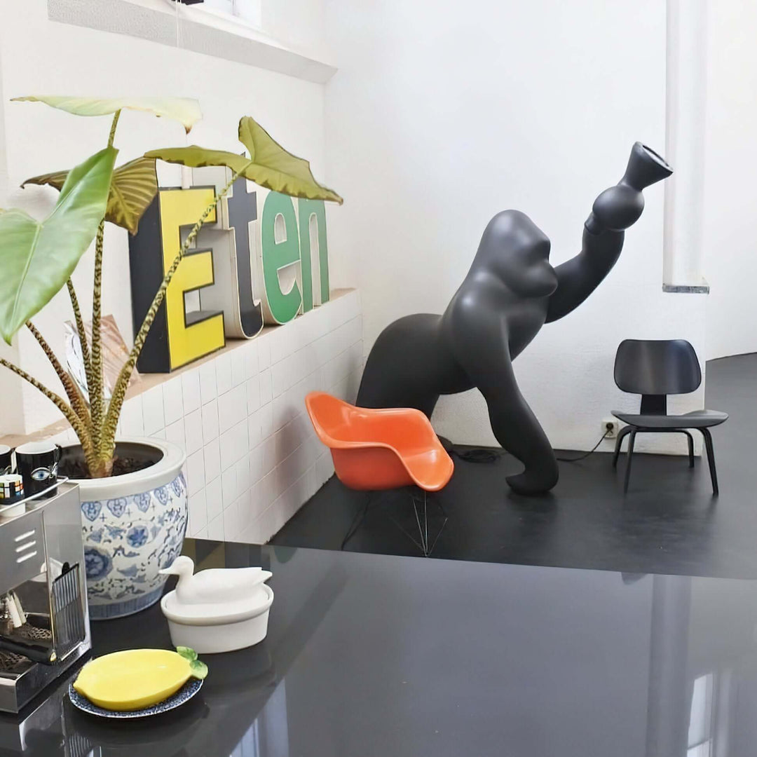 Stylish living room featuring a Kong sculpture floor lamp, colorful chairs, and decorative plants for a contemporary look.