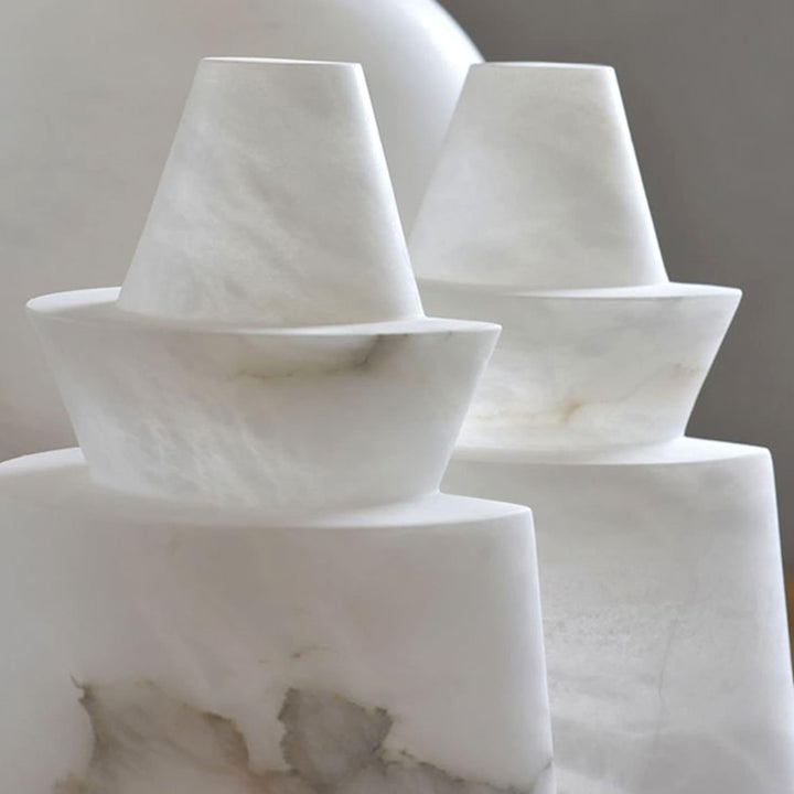 Alabaster decorative sculptures featuring various geometric shapes in a soft, elegant design.