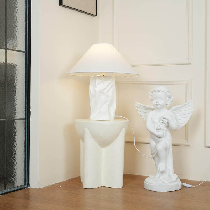 Minimal white table lamp beside a modern sculpture, perfect for bedroom bedside decor.