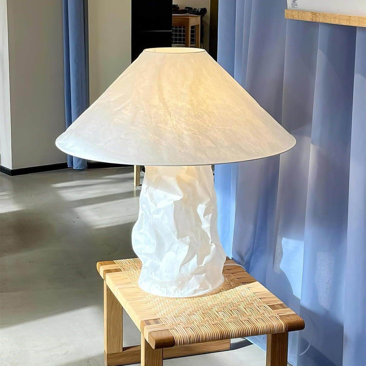 Minimal white table lamp on wooden table, ideal for bedroom bedside lighting.