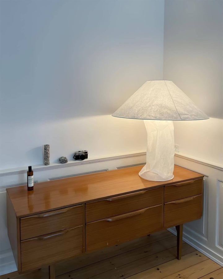 Minimal white table lamp on a wooden sideboard, perfect for bedroom bedside decor.