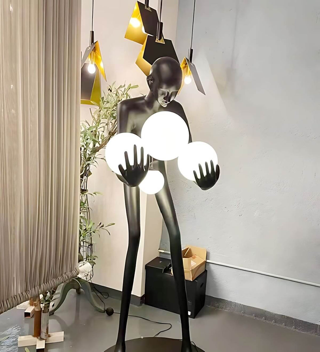 Light Guardian Floor Lamp in Art Deco style, featuring a black resin sculpture holding glowing orbs for stylish living room decor.
