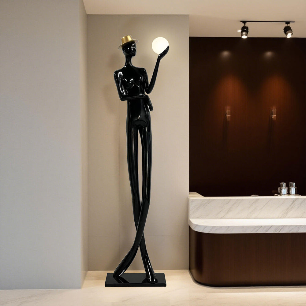 Sculptural floor lamp showcasing an elegant black figure holding a globe light, perfect for modern living room decor.