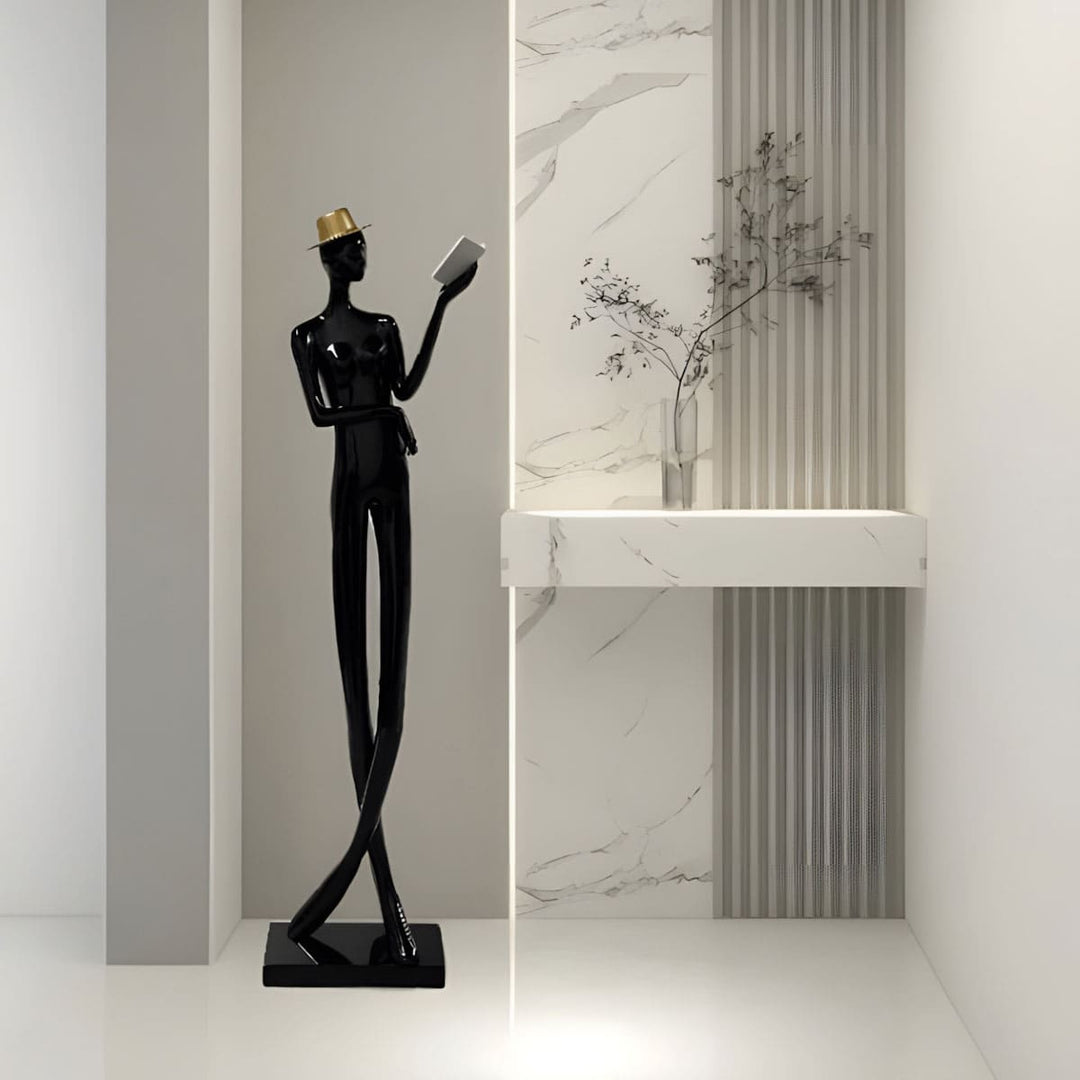 Sculptural floor lamp in art deco style, featuring a black statue of a man reading, perfect for modern living rooms.