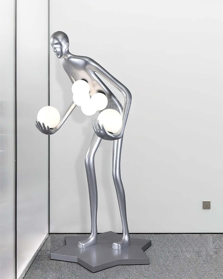 Sculptural floor lamp in silver with a unique human-like shape, holds glowing orbs, perfect for contemporary art deco decor.