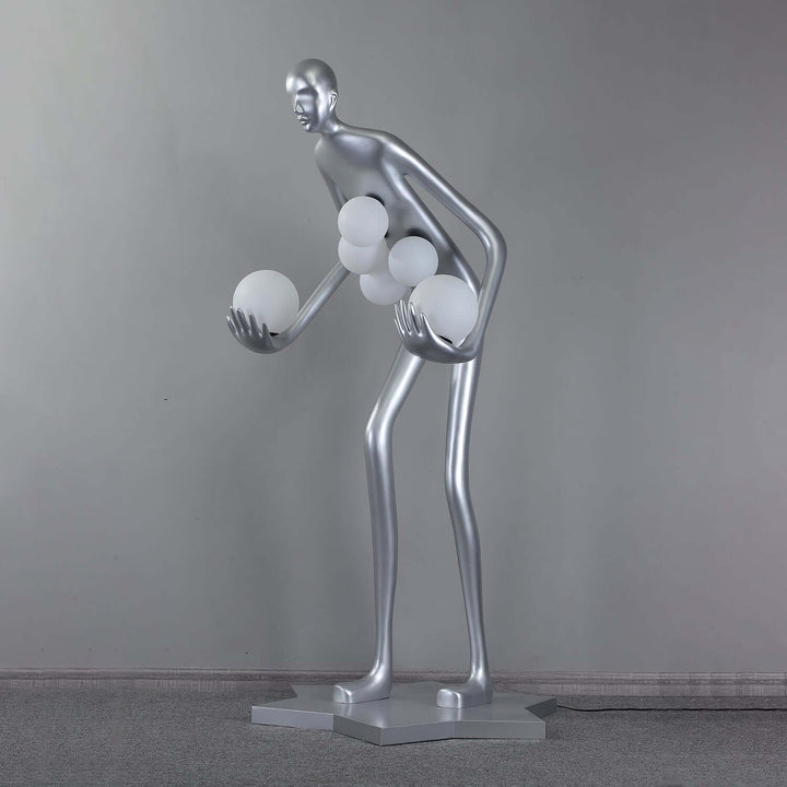 Sculptural silver floor lamp featuring an abstract human form with spherical light orbs, perfect for modern living room decor.